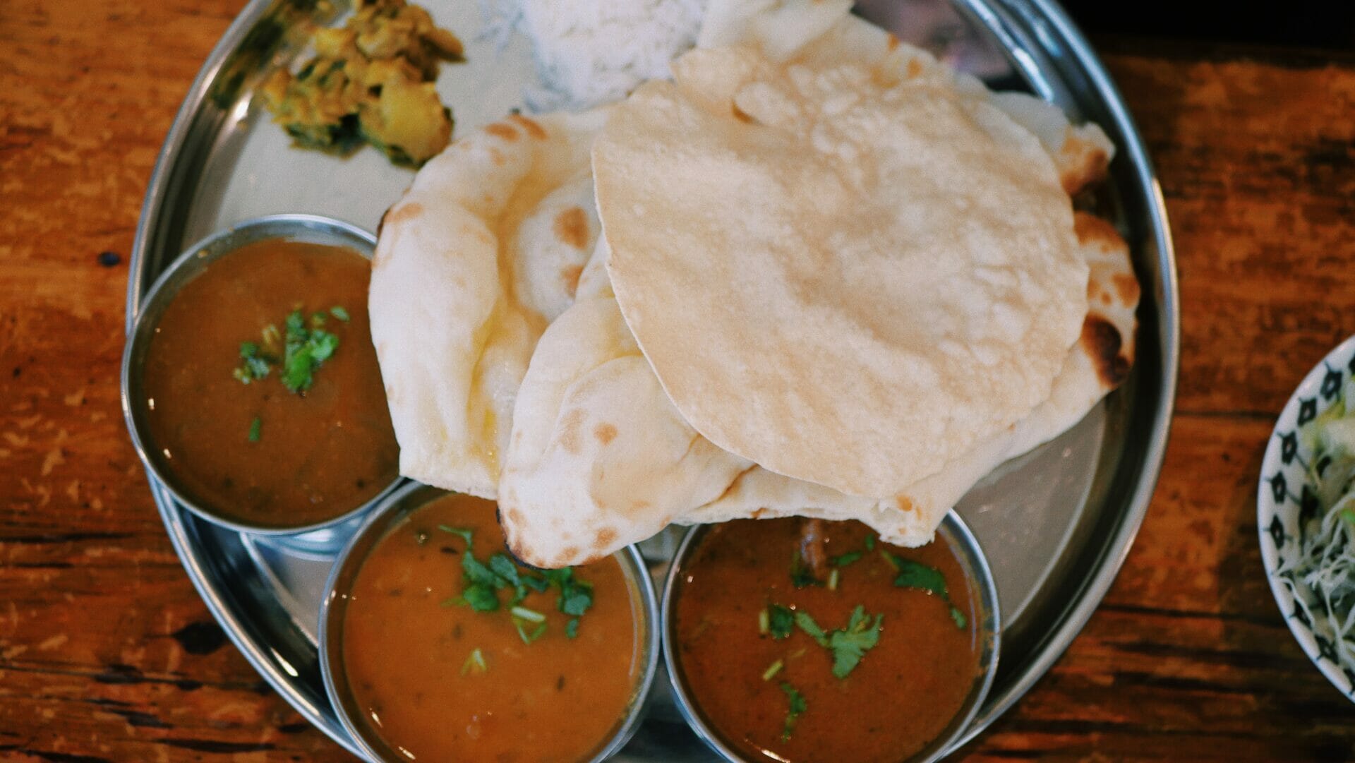 Bowls of soup and bread on a wooden table.