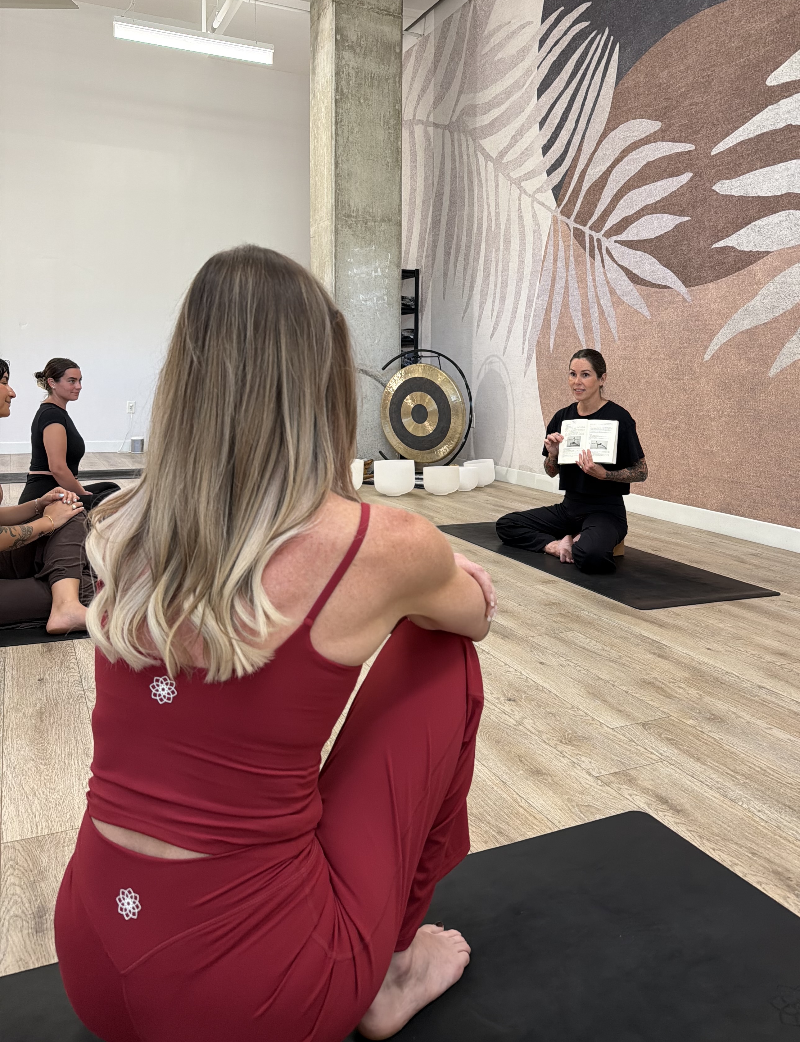 A yogi woman on a yoga mat in a lunge position with her arms raised above her head